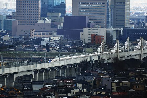 富山駅を出発し、神通川橋りょうを通過し金沢方向へ進む北陸新幹線