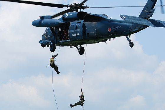 遭難者を救助するためUH-60Jから降下する2名の隊員