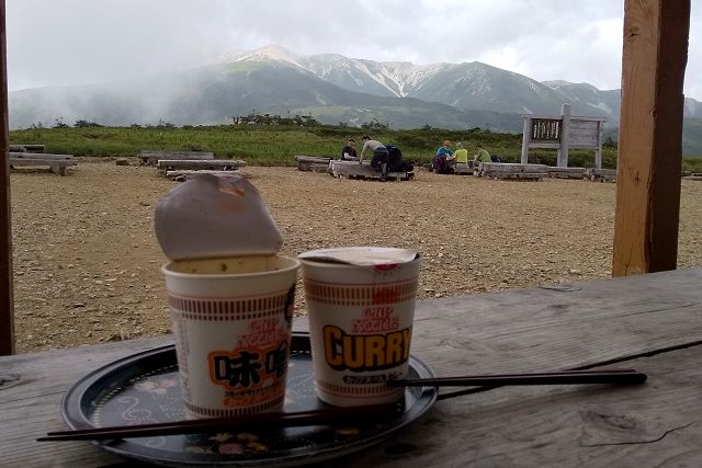 太郎平小屋でカップ麺を食べながら薬師岳を眺める