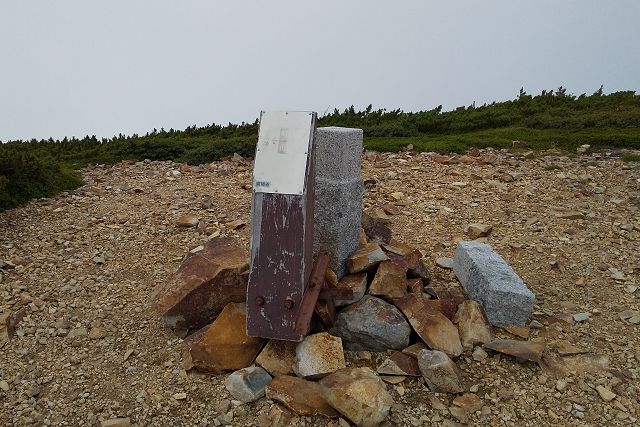 間山の山頂にある指導標と三角点の石柱