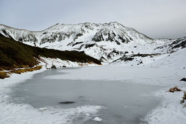 結氷した白いみどりが池と立山